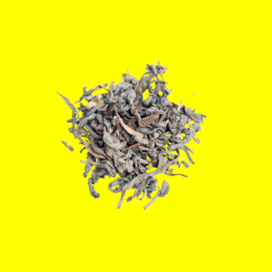 A pile of dried tea leaves on a bright yellow background.