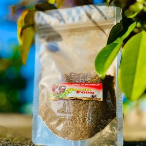 Packaged herbal powder with green leaves in sunlight.