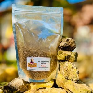 A sealed bag of herbal tea mix placed on a pile of rocks outdoors.