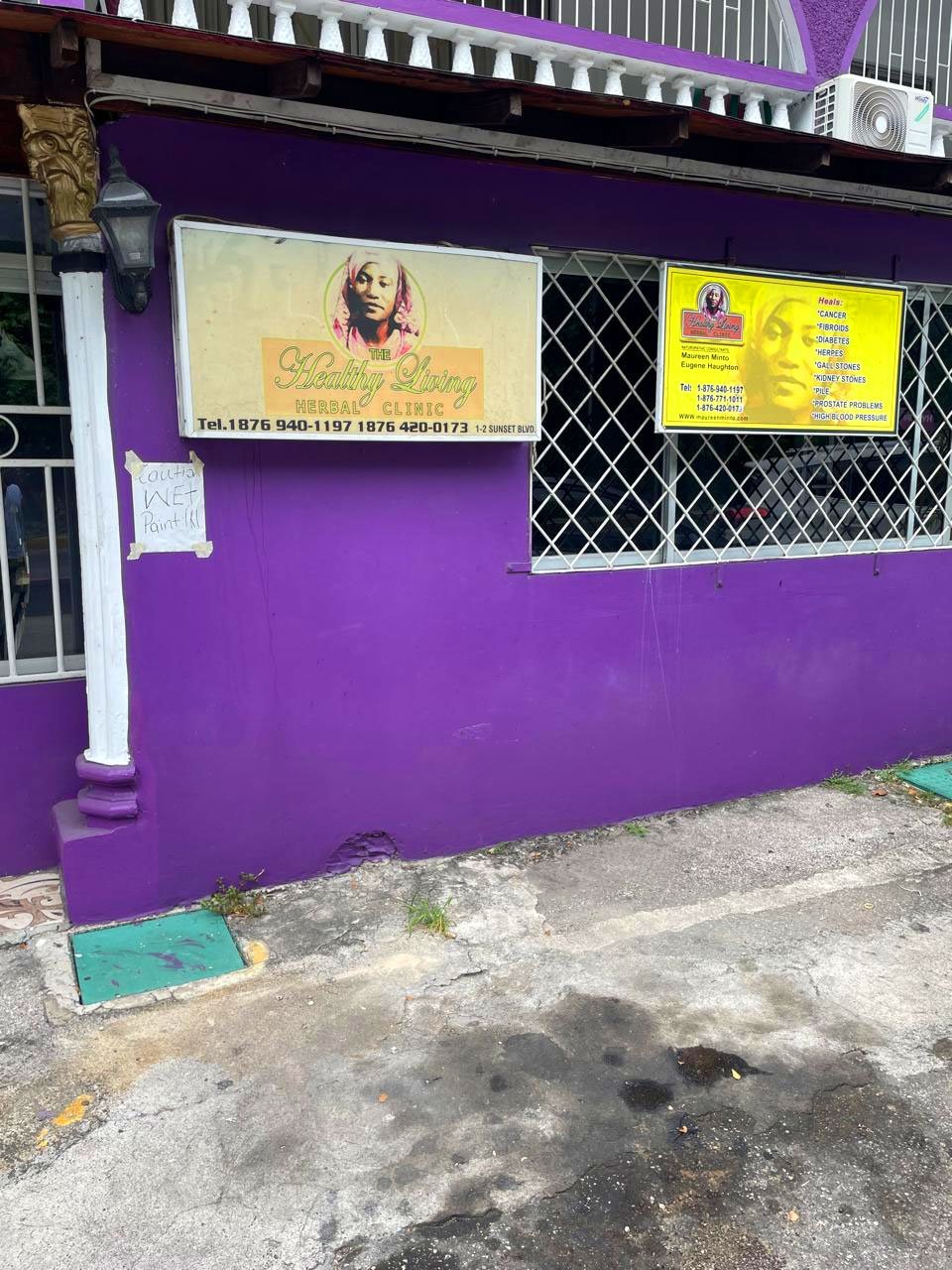 Purple building with two yellow signs about a spiritual or wellness center.