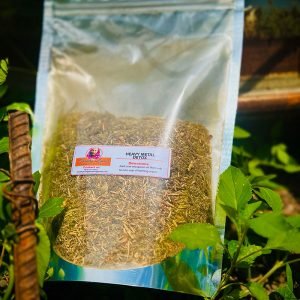 A sealed bag of organic fenugreek seeds placed outdoors with green foliage.