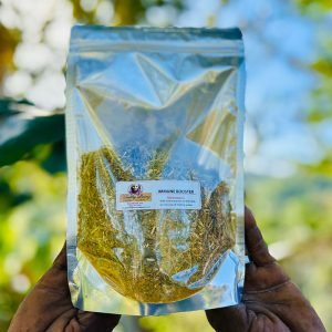 Hand holding shiny packaging of organic tea leaves outdoors.