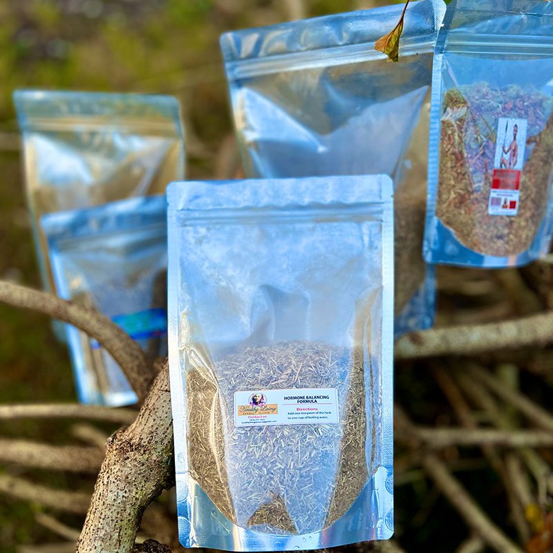 Multiple silver resealable bags containing food products displayed on tree branches.