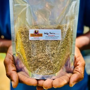 Person holding a clear bag of longan seeds with a label.