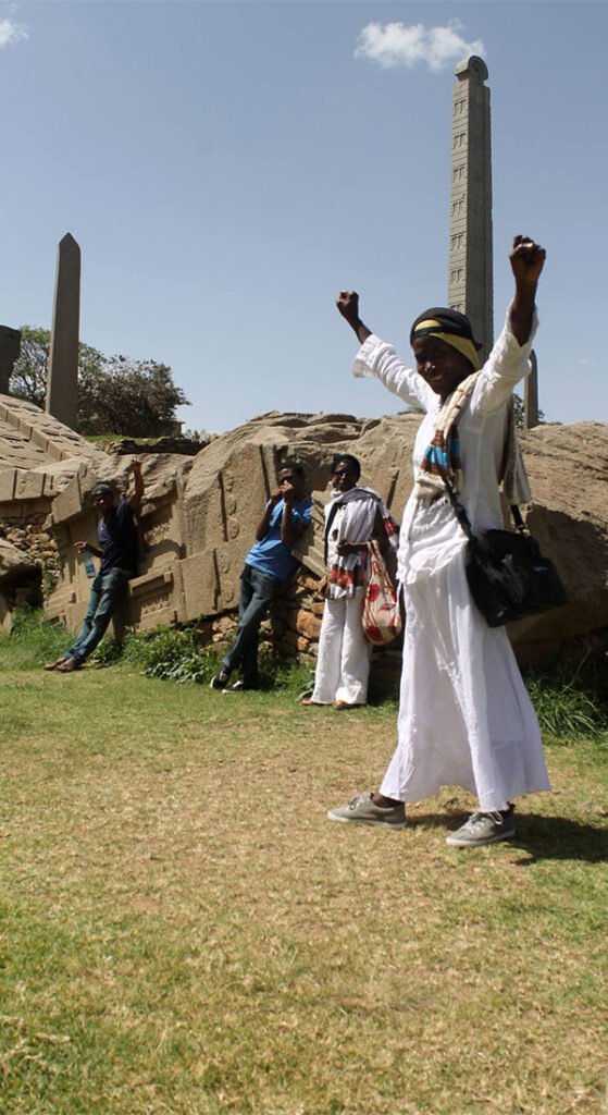 Smiling young woman with acne, wearing a white t-shirt.