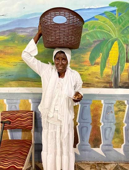 Smiling young woman with acne, wearing a white t-shirt.